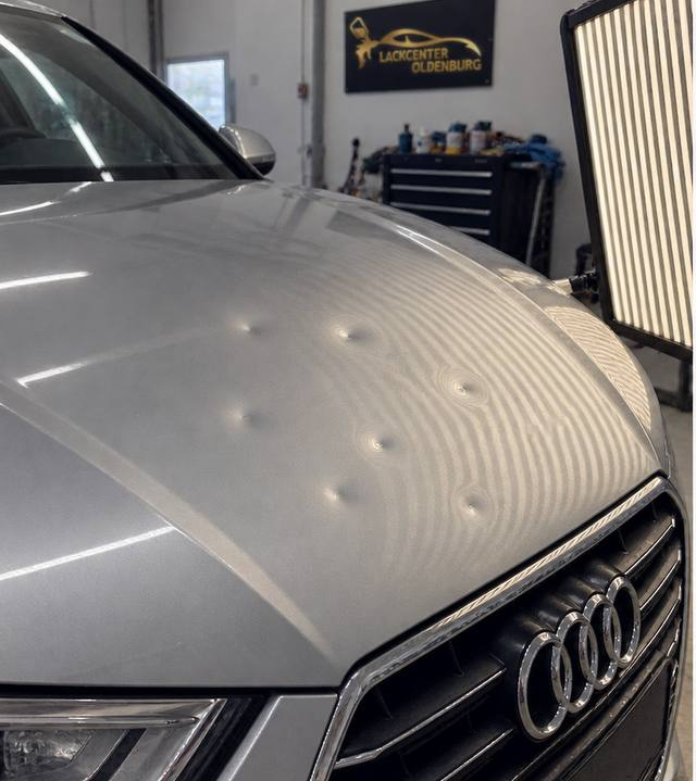 Hagelschaden mit Dellen auf der Motorhaube vor der Reparatur